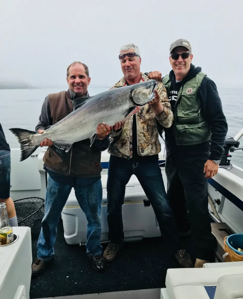 3 men showing off their biggest catch of the day