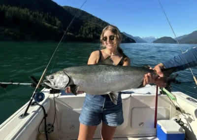 woman proudly showing off a huge salmon catch
