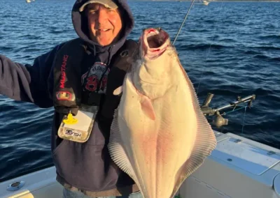 man displaying his large halibut catch