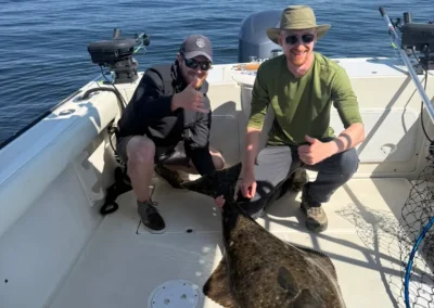 Two people showing off a huge halibut caught with Campbell River Fishing Guide